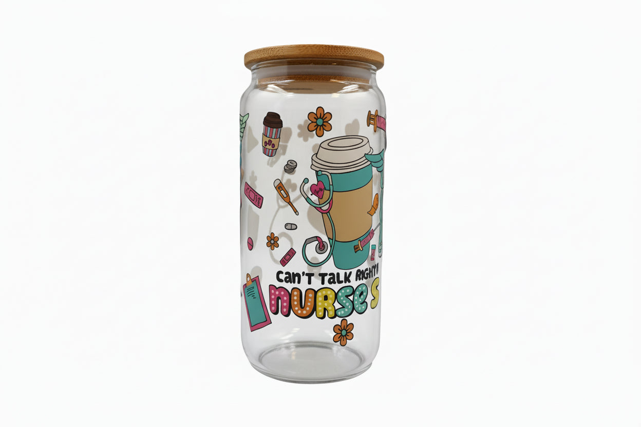 Clear glass tumbler with colorful design and text on a white surface