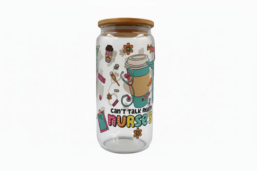 Clear glass tumbler with colorful design and text on a white surface